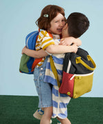 Two children each wearing a Fluf junior organic cotton backpack.