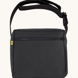 The carbon black coloured Fluf Crossbody Bag. The bag has a black zip and strap.