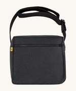 The carbon black coloured Fluf Crossbody Bag. The bag has a black zip and strap.
