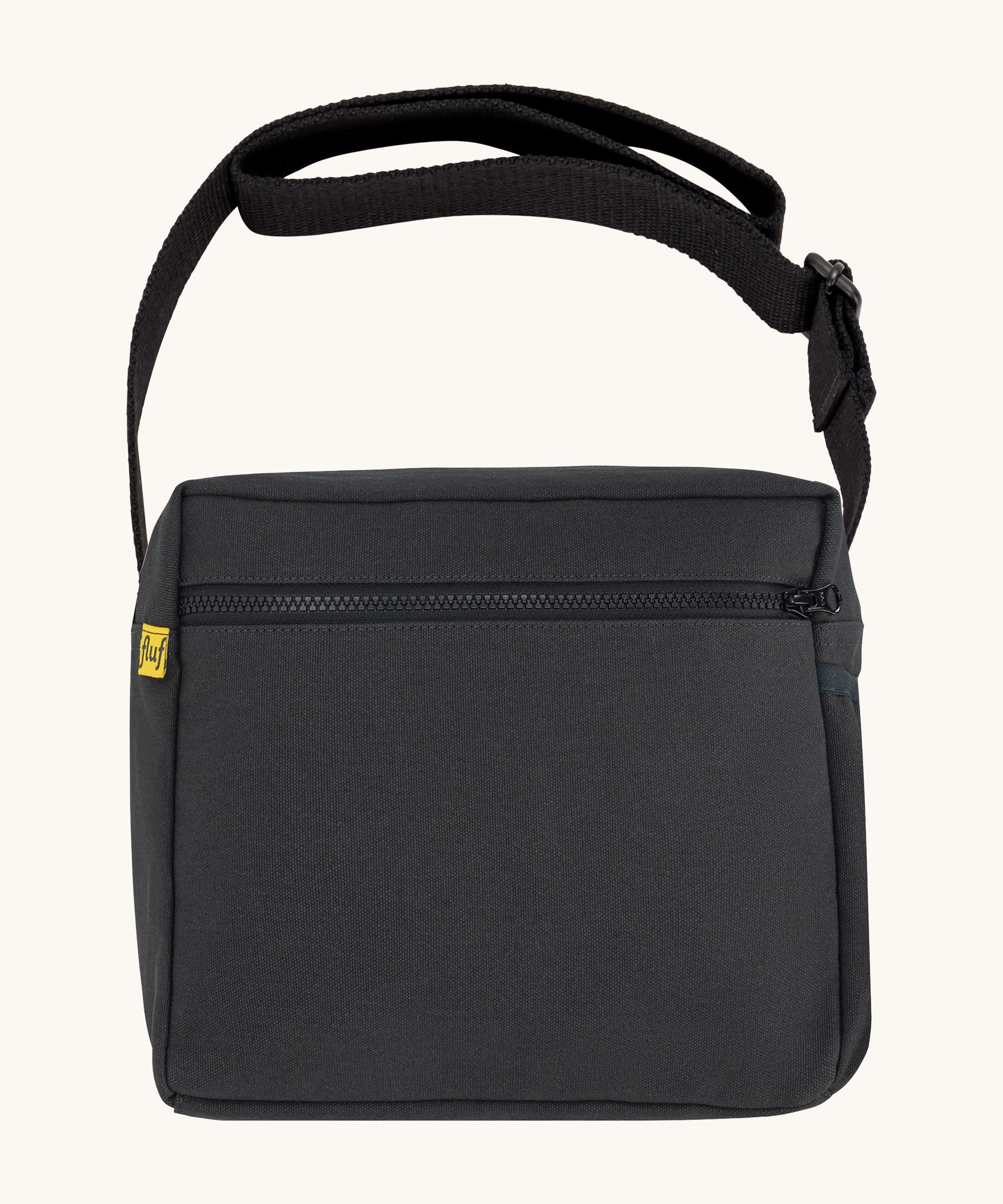 The carbon black coloured Fluf Crossbody Bag. The bag has a black zip and strap.