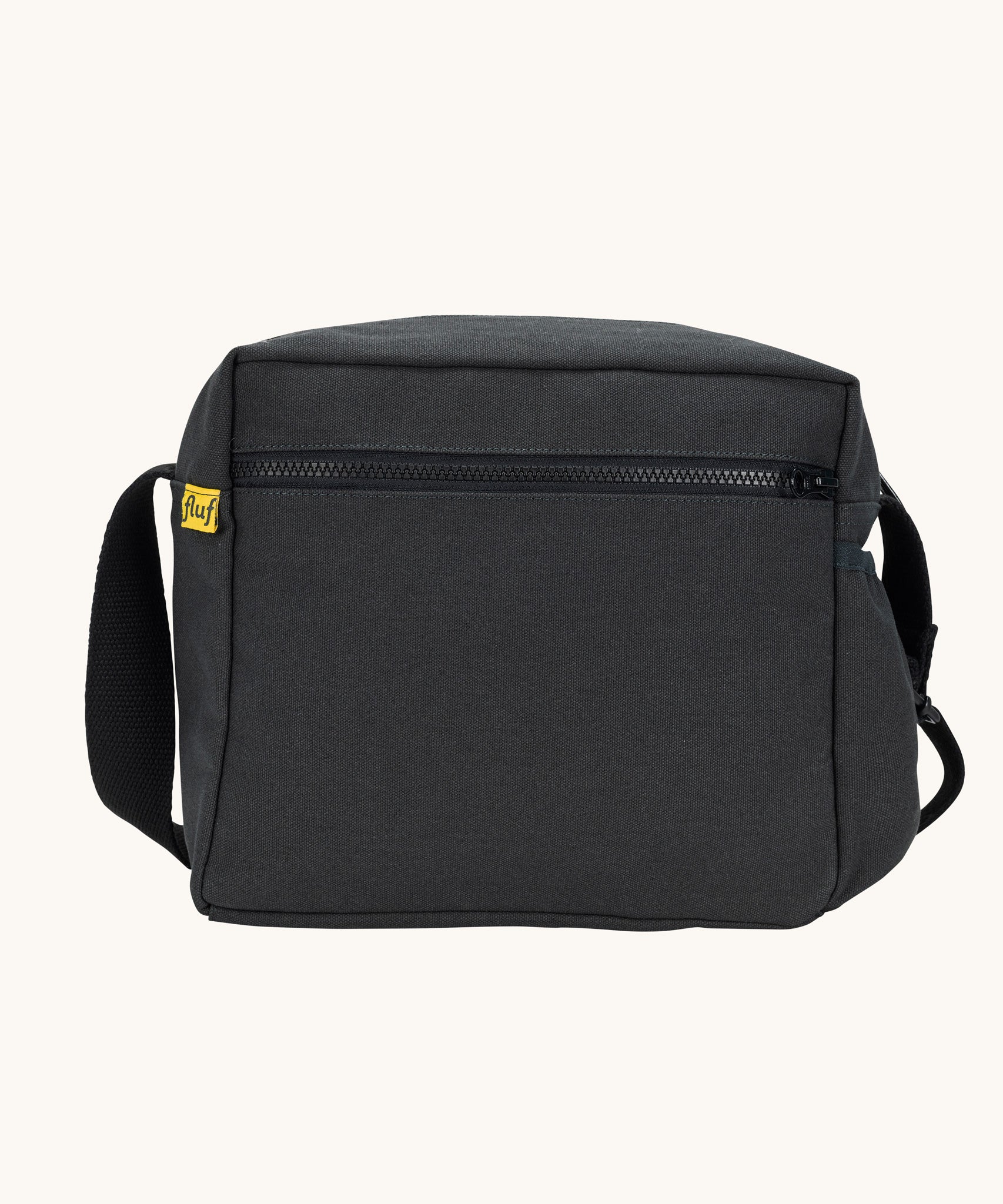The carbon black coloured Fluf Crossbody Bag. The bag has and off white coloured zip an crossbody strap.