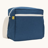 A side angle view of the classic navy coloured Fluf Crossbody Bag. The bag has and off white coloured zip an crossbody strap.