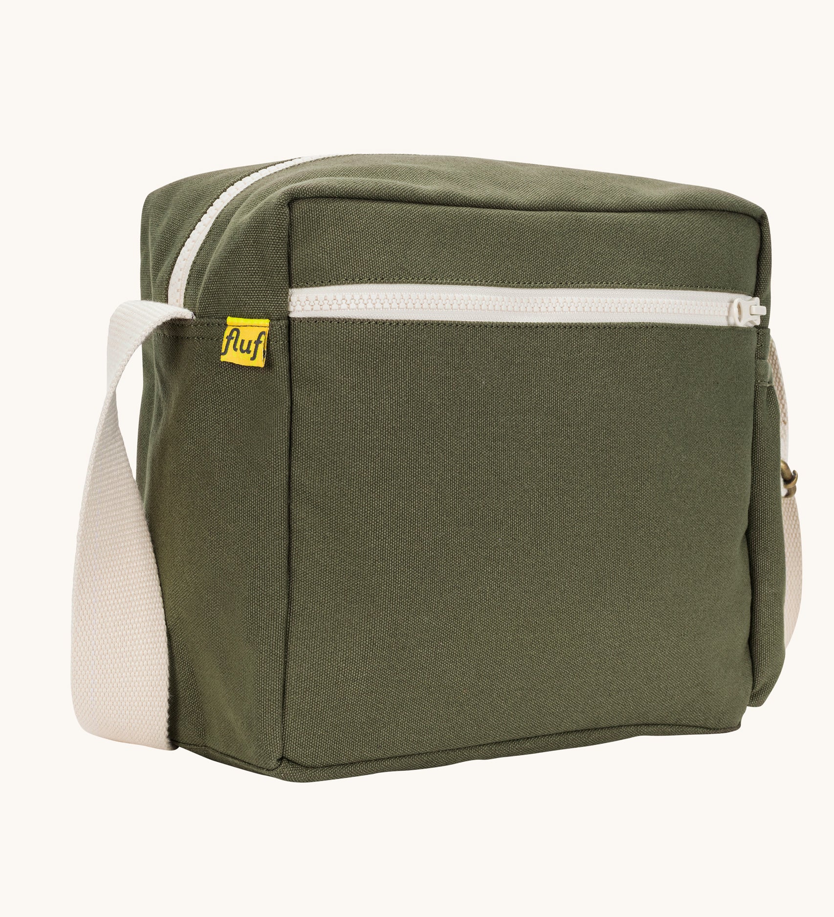 A side angle view of the dark olive green coloured Fluf Crossbody Bag. The bag has and off white coloured zip an crossbody strap.
