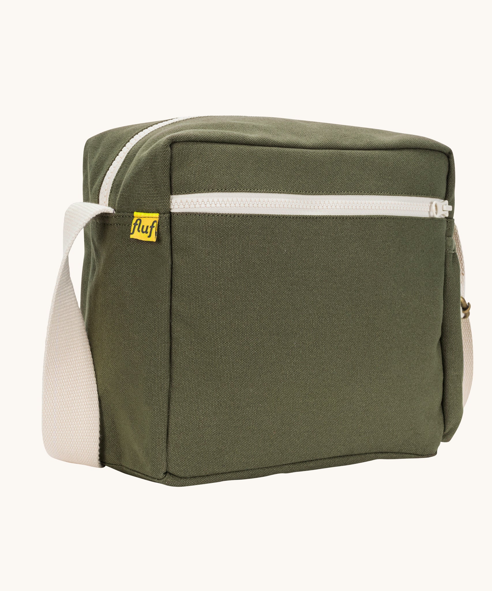 A side angle view of the dark olive green coloured Fluf Crossbody Bag. The bag has and off white coloured zip an crossbody strap.