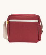 The vintage burgundy coloured Fluf Crossbody Bag. The bag has and off white coloured zip an crossbody strap.