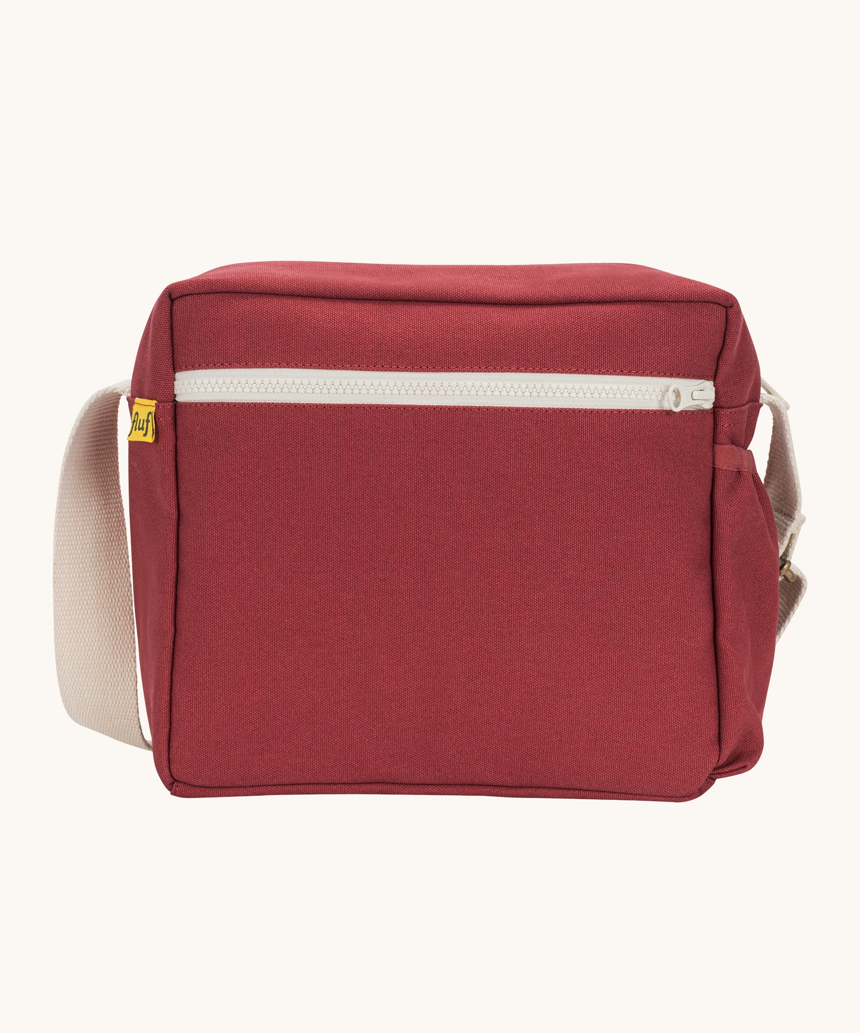 The vintage burgundy coloured Fluf Crossbody Bag. The bag has and off white coloured zip an crossbody strap.