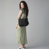 A woman carrying the adjustable strap organic cotton crossbody lunch bag from Fluf in black