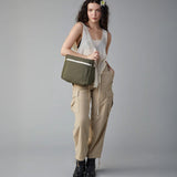 A woman modelling the Fluf organic cotton crossbody everyday lunch bag in olive green
