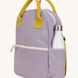 The organic cotton kids Fluf B-Pack Jr in lavender purple, the backpack is zipped up and there's a reusable water bottle in the side pocket.