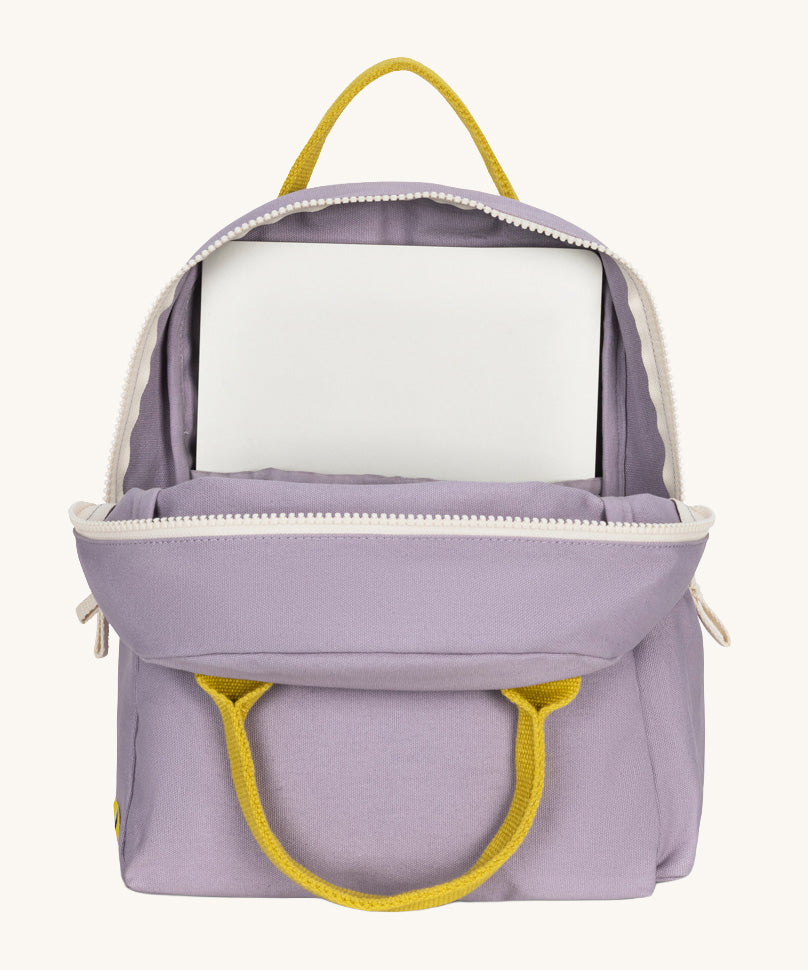 The organic cotton kids Fluf B-Pack Jr in lavender purple, the backpack is unzipped and there's a small laptop inside.