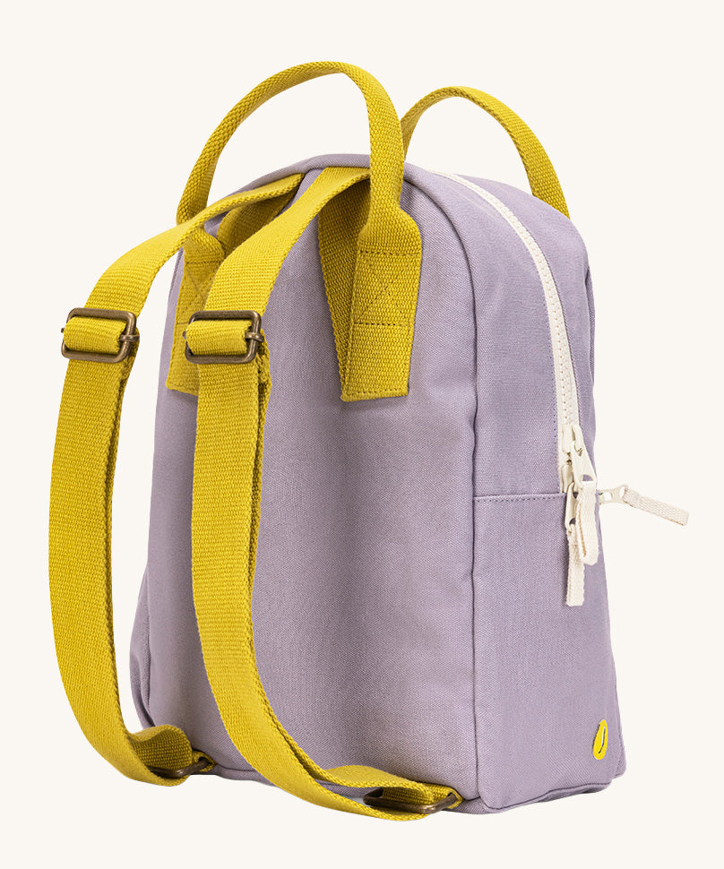 The back of the The organic cotton kids Fluf B-Pack Jr in lavender purple. The bag has yellow coloured straps.