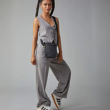 A woman in a trendy casual office wear suit, carrying the Fluf organic cotton mini crossbody bag in black