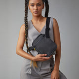 A woman in a trendy casual office wear suit, carrying the Fluf organic cotton mini crossbody bag in black
