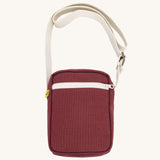 Burgundy Fluf Mini Crossbody Bag made from GOTS certified organic cotton with recycled lining, sporty and stylish travel organiser with front zipper pocket and adjustable shoulder strap