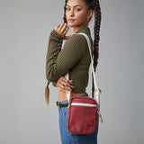 A woman modelling the Fluf organic cotton snack mini crossbody bag in burgundy, perfect for a festival bag