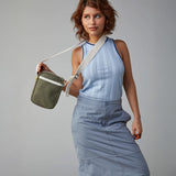A trendy woman holding the Fluf organic cotton , machine washable Mini Crossbody sports and travel bag  in olive green