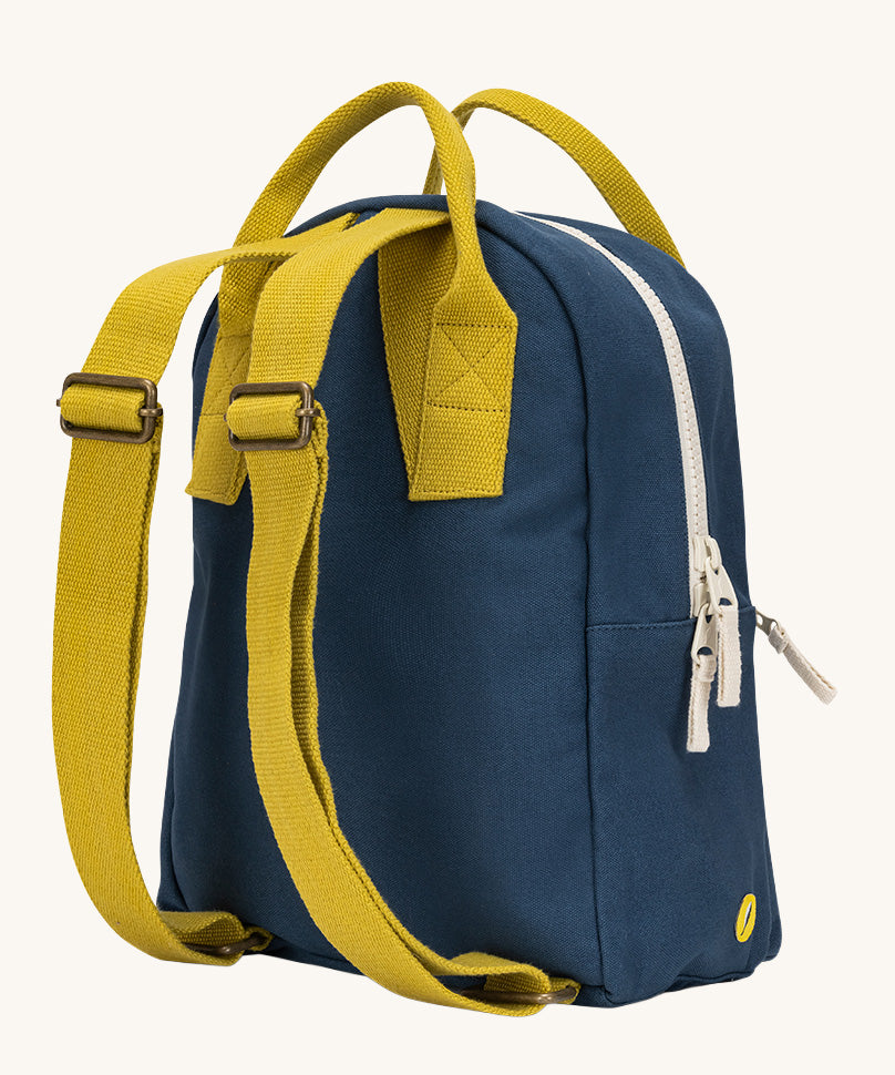A view of the back of the organic cotton kids Fluf B-Pack Jr in navy blue, the backpacks yellow straps.