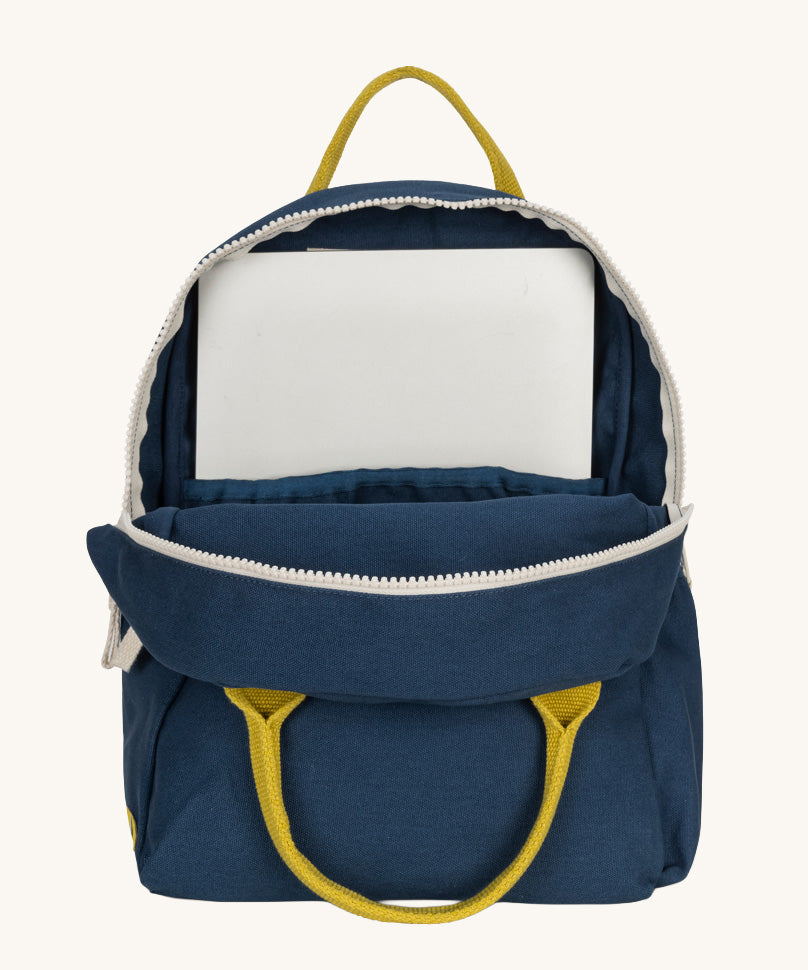 The organic cotton kids Fluf B-Pack Jr in navy blue, the backpack is unzipped and there's a small laptop inside.