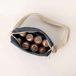 A top view of the Fluf organic cotton crossbody everyday lunch bag in navy, with eight soda cans inside to indicate the scale.