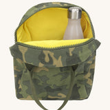 The Fluf organic cotton zippered lunch bag with a water bottle inside, in a green camo print with dark green handles and a yellow inside lining.