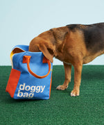 A dog taking a good look inside the Fluf organic cotton zippered doggy bag design lunch bag. The dog has his nose in the bag