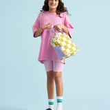 A young person holding Fluf organic cotton zippered lunch bag, featuring the checks pear design.