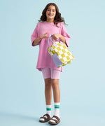 A young person holding Fluf organic cotton zippered lunch bag, featuring the checks pear design.