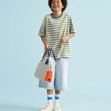 A child holding a Fluf organic cotton zippered lunch bag, featuring the nautical pencil stripe design.