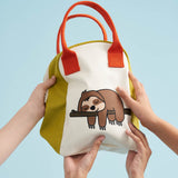 The Fluf organic cotton zippered lunch bag, featuring a sloth design on the front, orange handles and green side panels. Hands can be seen holding up the bag.