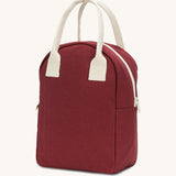 A side view of the Fluf organic cotton zippered lunch bag, in a vintage burgundy colour with a white zip and handles.
