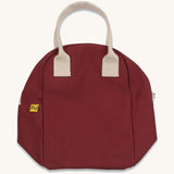 The Fluf organic cotton zippered lunch bag, in a vintage burgundy colour with white handles, squashed flat.