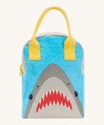 Fluf zip lunch bag in light blue and grey with a design of a shark's head on the bottom with a yellow handle and zip detail on a cream background.