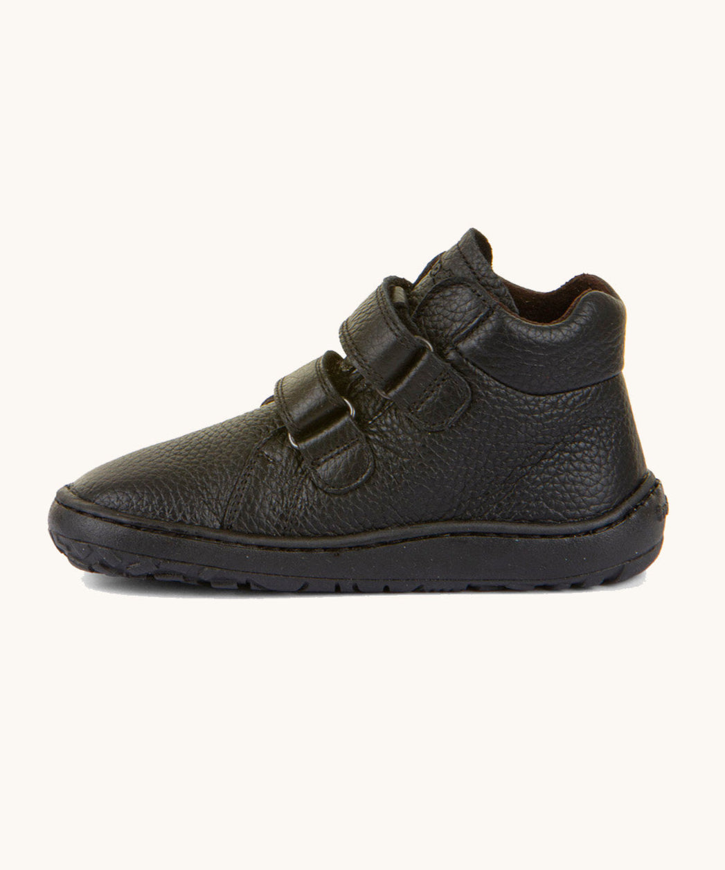 A side image of a Froddo barefoot Autumn children's shoe in black available at Babipur showing the 2 velcro fastener for a secure fit, padded ankle and the matching black grippy sole