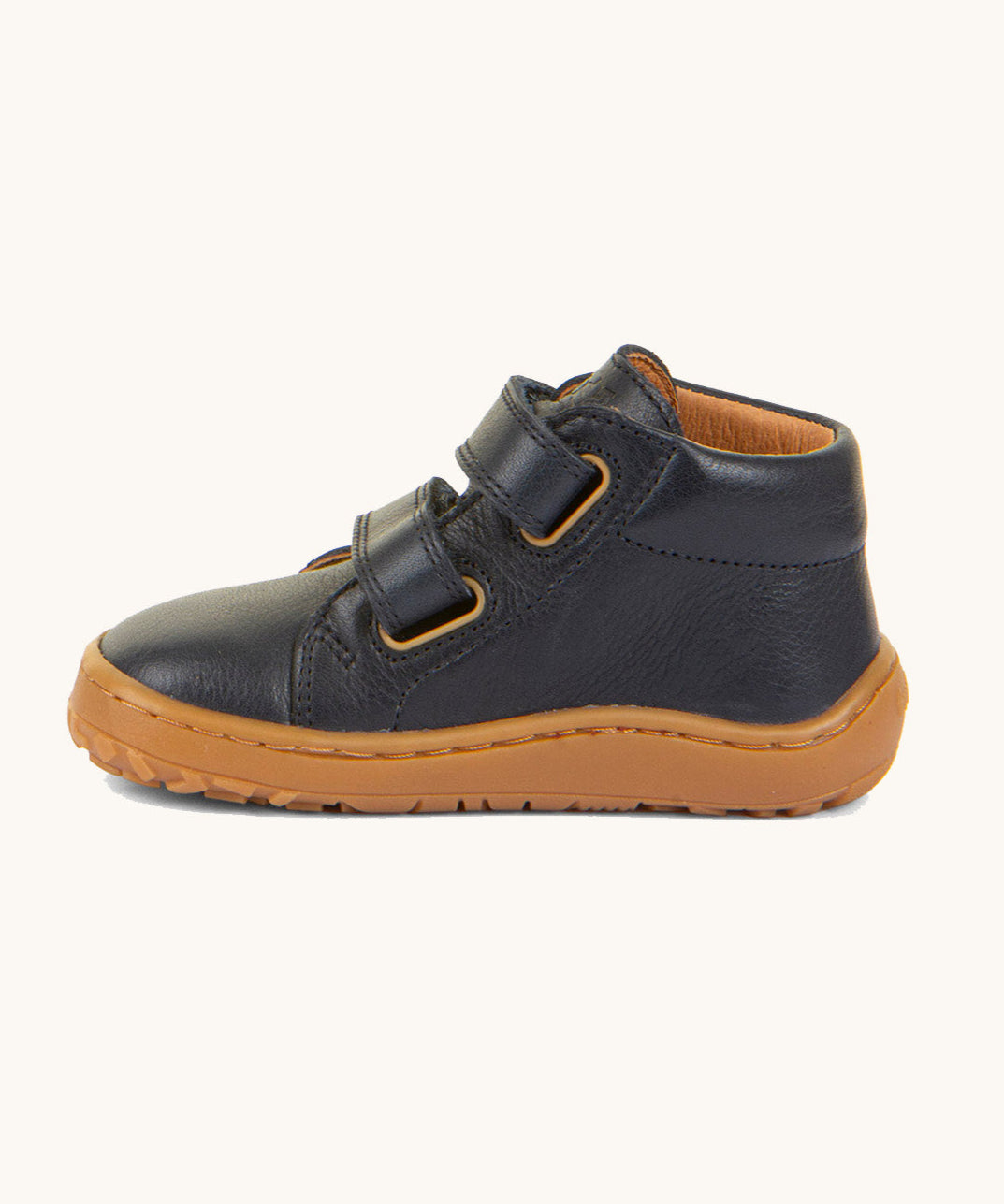 A side image of the Froddo barefoot first step baby shoe in dark blue available at Babipur showing the 2 velcro fastener for a secure fit and the grippy sole detail