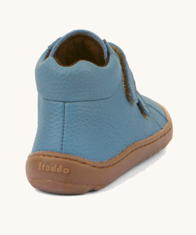 The back of a Froddo barefoot Autumn children's shoe in light blue denim colour available at Babipur showing the padded ankle support and the dark brown grippy sole detail