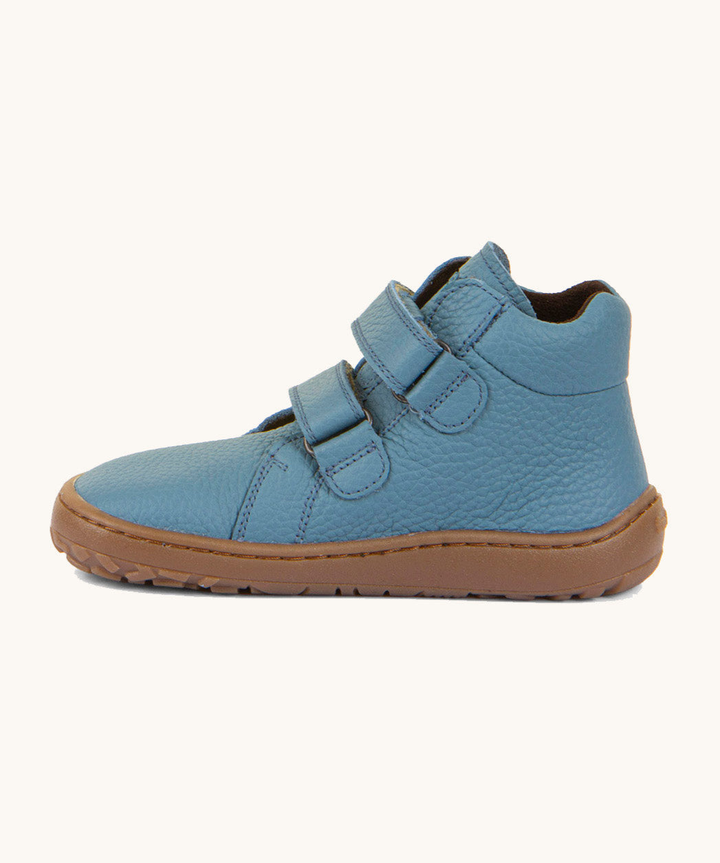 A side image of a Froddo barefoot Autumn children's shoe in light blue jeans colour available at Babipur showing the 2 velcro fastener for a secure fit, padded ankle and the dark brown grippy sole