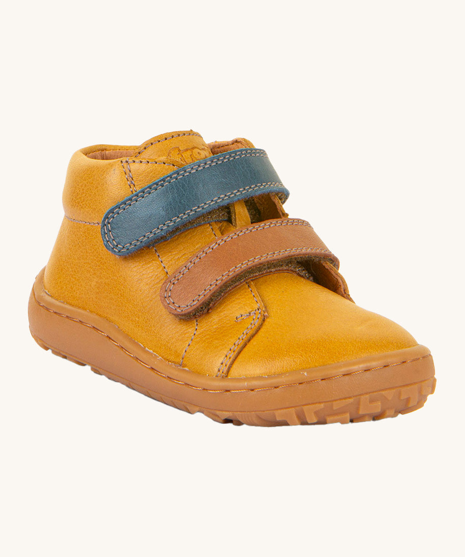 Froddo barefoot first step baby shoe in mustard. A dark yellow natural leather shoe with a 2 velcro fastener for a secure fit in blue and brown and a grippy sole