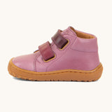 A side image of the Froddo barefoot first step baby shoe in pink available at Babipur. Showing the 2 darker pink velcro fastener for a secure fit and the light brown grippy sole
