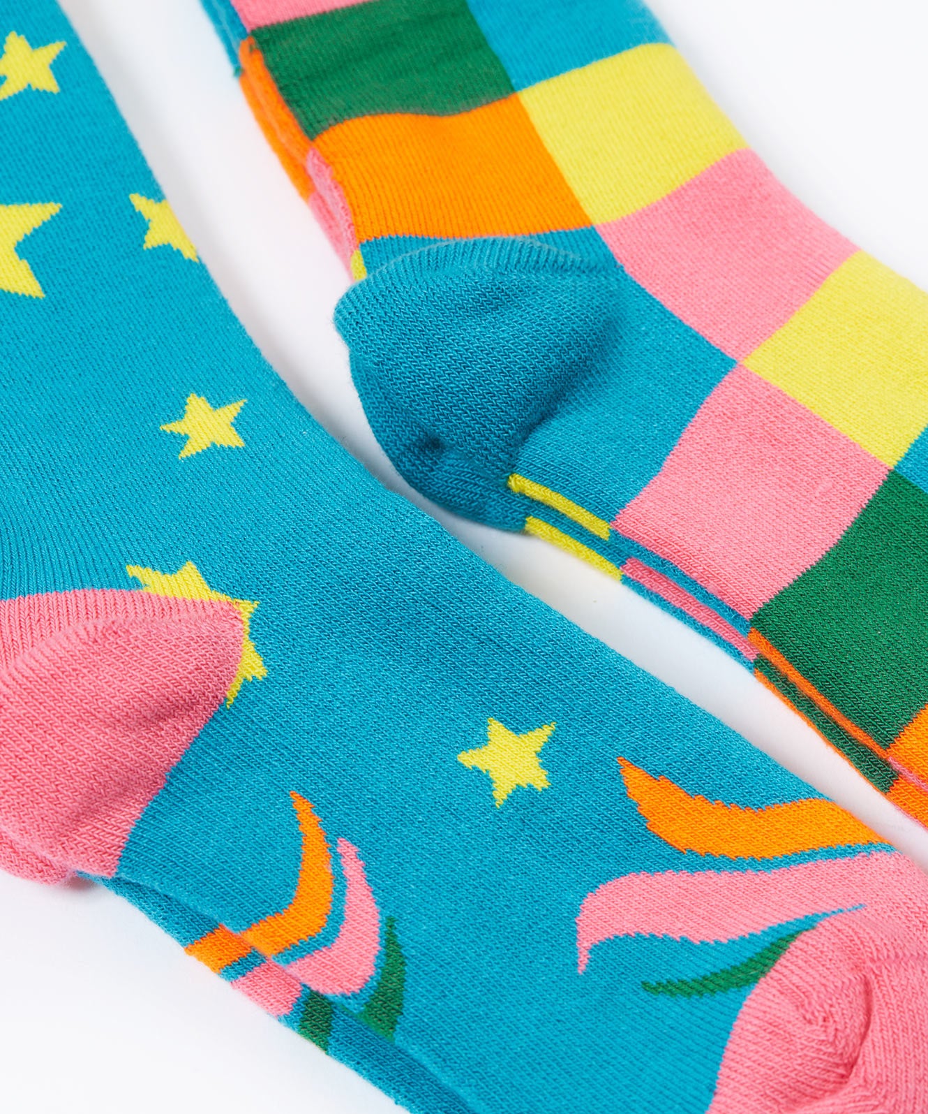 A close up of the Frugi 2 pack rainbow brilliant boot socks showing the pink and light blue heal detail on organic cotton fabric
