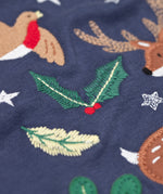 A close up of the embroidered holly detail on the front of the Frugi navy reindeer applique  Organic Cotton Anna long sleeved Top. This top is a part of a wide range of organic cotton clothing for children available here at Babipur.