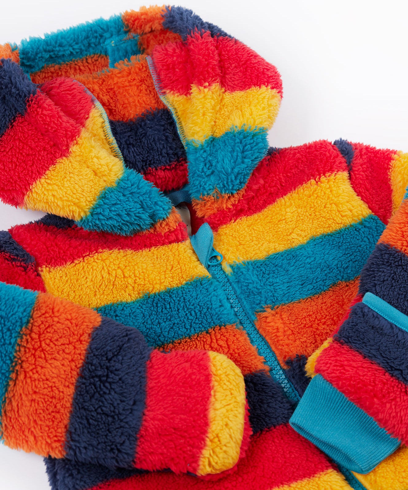 A close up o the Frugi kids recycled cosy snuggle suit in autumn stripe showing the blue zip detail and matching blue cuff on thick warm recycled textile fabric.