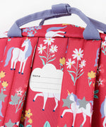 A close up of the back of the Frugi rose unicorn floral explorer backpack showing the name tag patch detail on the top of the bag in between the shoulder straps.