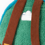 A close up of the  Frugi kids beary wild backpack. Showing the brown corduroy shoulder straps on the green fleece back panel with the name patch stitched in between.