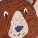 A close up of the  Frugi kids beary wild backpack. Showing the brown corduroy brown bear face detail - features a neutral colour nose trim