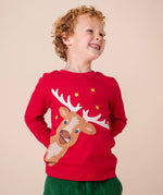 A child wearing the Frugi Berry Red Reindeer Terrific Circular Organic Cotton long sleeved kids Top available at Babipur. A red coloured children's top with a festive reindeer applique and gold stars on the front.