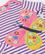 A close up of the butterfly applique detail on the front of the Frugi Children's organic cotton Bobby butterfly Applique purple striped  long sleeved Top. The top has a violet purple and white stripe background with a large decorated butterfly applique on the front. This top is a part of a wide range of organic cotton clothing for children available here at Babipur.