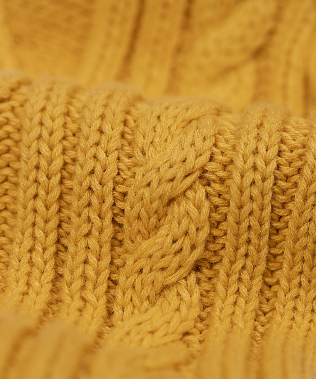 A close up of the cable knit sleeves on the Frugi Caleb leopard Character Knit Organic Cotton Kids' Jumper. This knitted jumper is a part of a wide range of organic cotton clothing for children available here at Babipur.