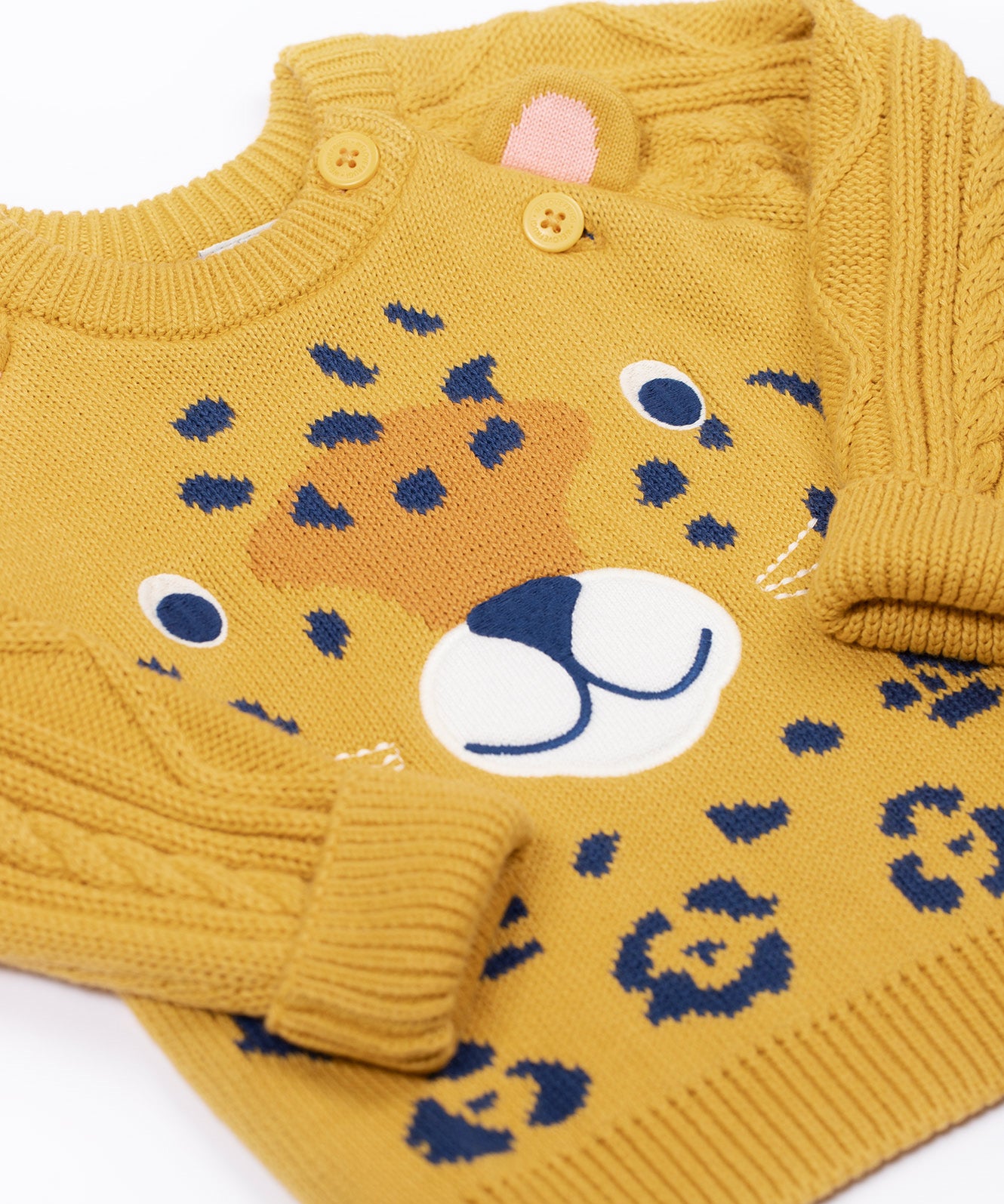 A close up of the leopard's face on the Frugi Caleb leopard Character Knit Organic Cotton Kids' Jumper. This knitted jumper is a part of a wide range of organic cotton clothing for children available here at Babipur.