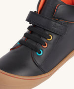 A close up of the coloured eyelets on the Frugi cape stretch children's lace boot in black leather with salamander orange leather lining.