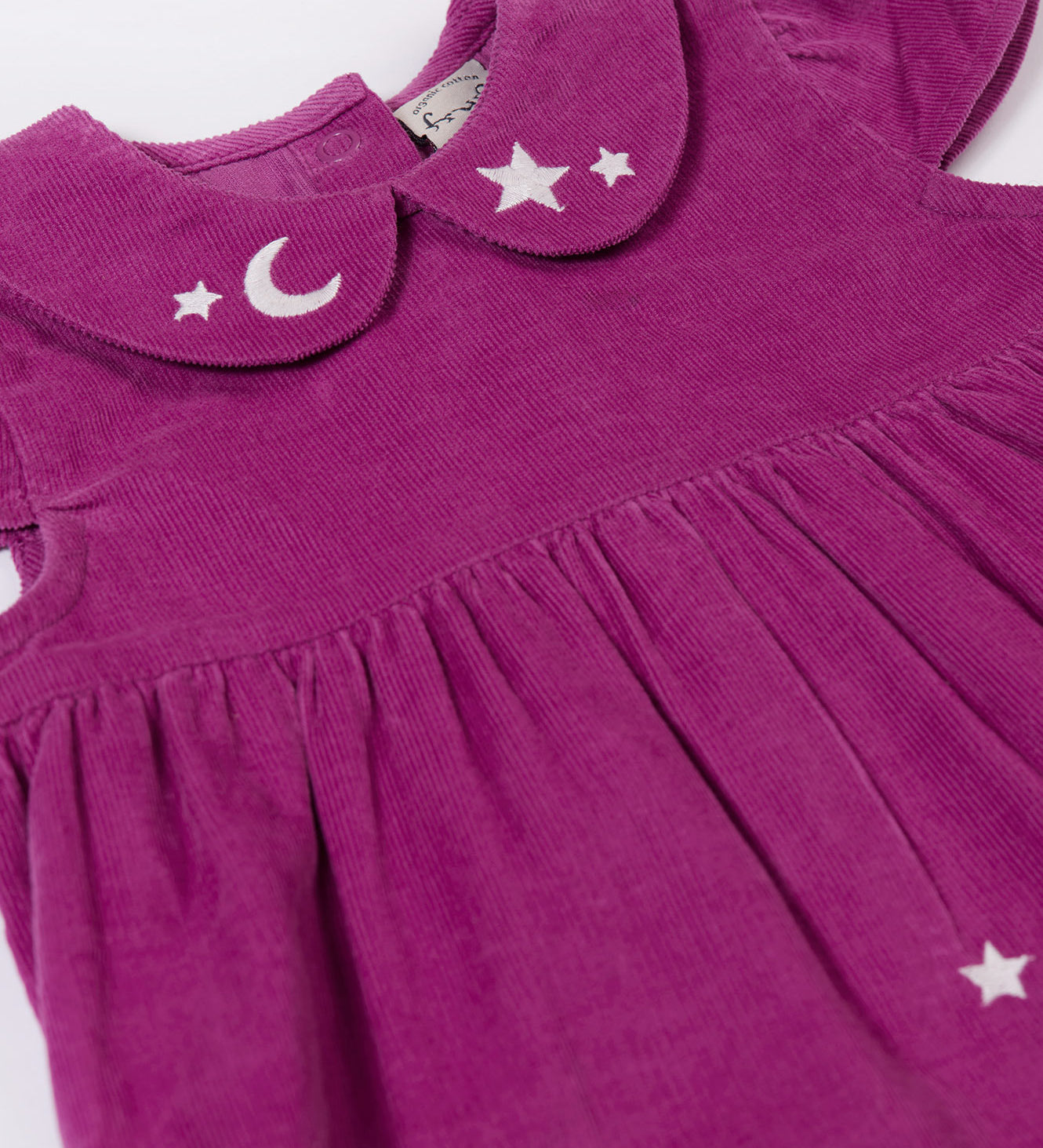 A close up of the embroidered moon and stars details on teh collar of the Frugi Damson purple Flowers Organic Cotton Vali Corduroy children's Dress. This cord kids dress is a part of a wide range of organic cotton clothing for children available here at Babipur.